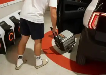 Fotografía oficial de la carga portátil de un coche sin carnet en un espacio interior.
persona conectando un cargador portatil a un coche sin carnet en un garaje