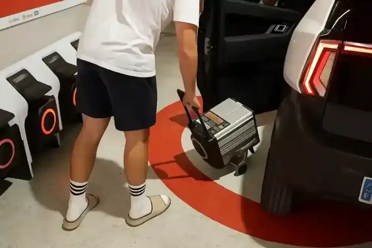 persona conectando un cargador portatil a un coche sin carnet en un garaje