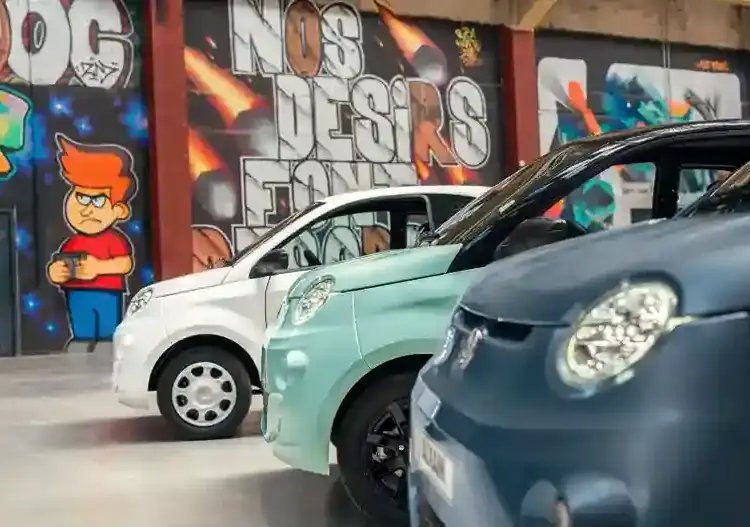 coche sin carnet Aixam eCity Easy blanco en imagen publicitaria con fondo naranja